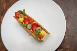 Dessert mit frischen Erdbeeren, Heidelbeeren und Minze auf weißem Teller – Foodfotografie