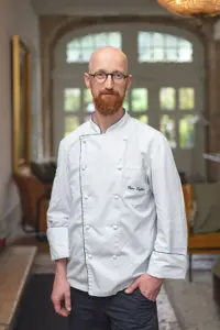 Porträt eines Küchenchefs in weißer Kochjacke im Restaurant