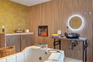 Modernes Pflegebad einer Tagespflege mit Badewanne, Kamin und Holzlamellen
